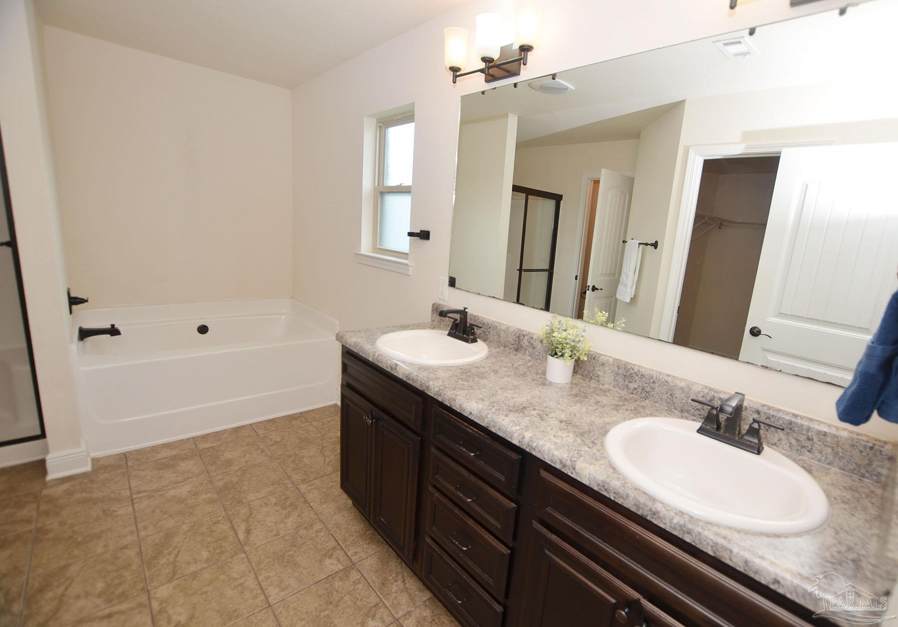 5709 Mill Stream Way Pace, FL 32571 - Photo 24 of 48 a bathroom with a granite countertop sink a toilet and bathtub