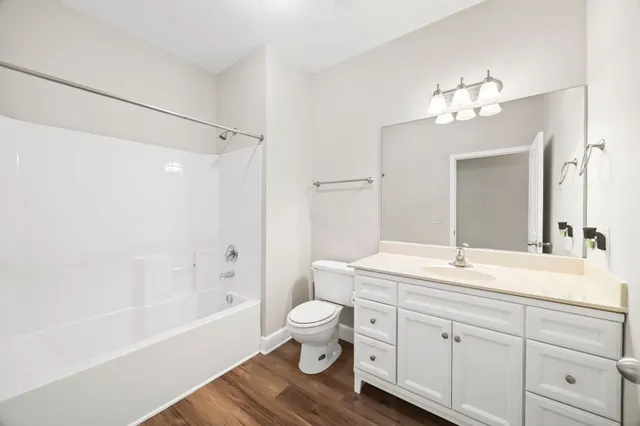 a bathroom with a sink a toilet and a large mirror
