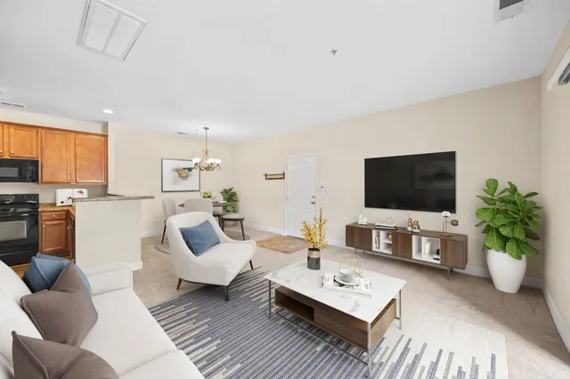 a living room with furniture a flat screen tv and a window