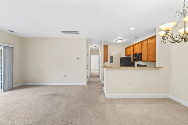 a view of kitchen with stainless steel appliances wooden floor and chair