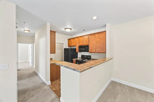 a kitchen with stainless steel appliances granite countertop a stove a sink and a refrigerator
