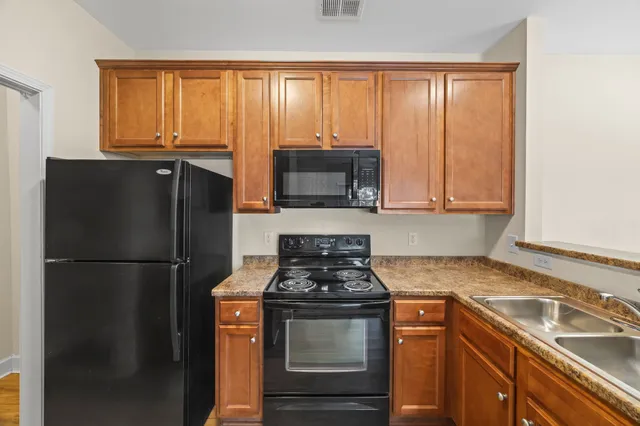a kitchen with granite countertop a refrigerator stove and sink