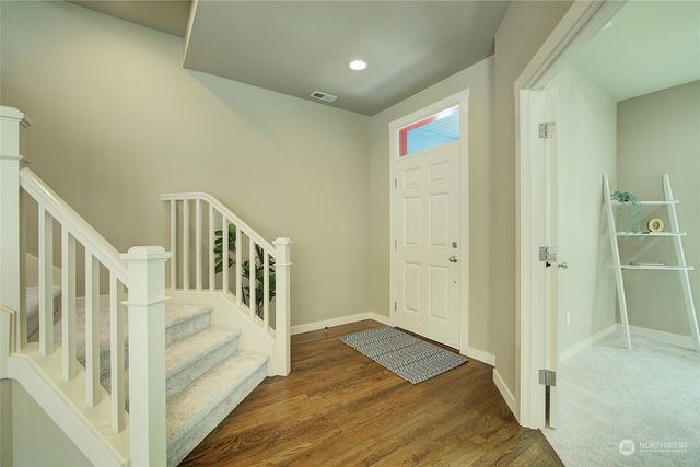 a view of a hallway with wooden floor and entryway