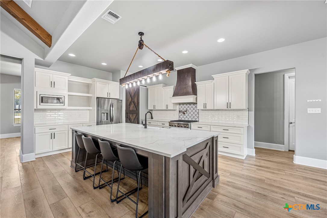 360 Grove Road Killeen, TX 76542 - Photo 15 of 48 a kitchen with stainless steel appliances a table chairs refrigerator and wooden floor
