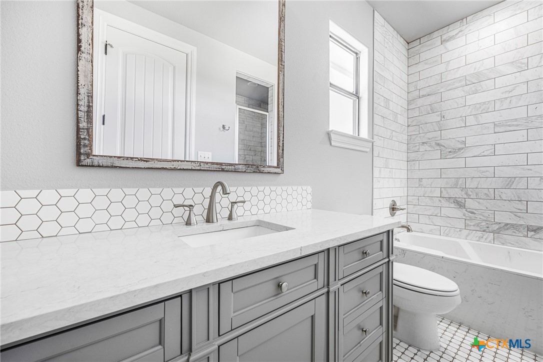 360 Grove Road Killeen, TX 76542 - Photo 20 of 48 a bathroom with a granite countertop sink a toilet and a bathtub