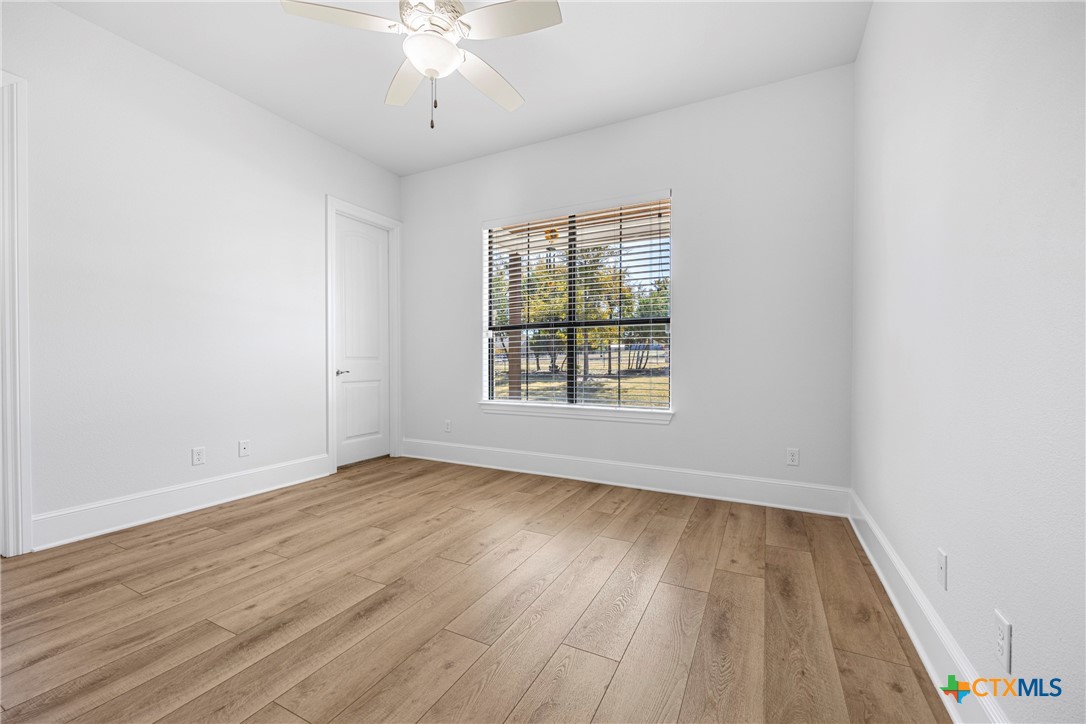 360 Grove Road Killeen, TX 76542 - Photo 32 of 48 an empty room with wooden floor chandelier fan and windows