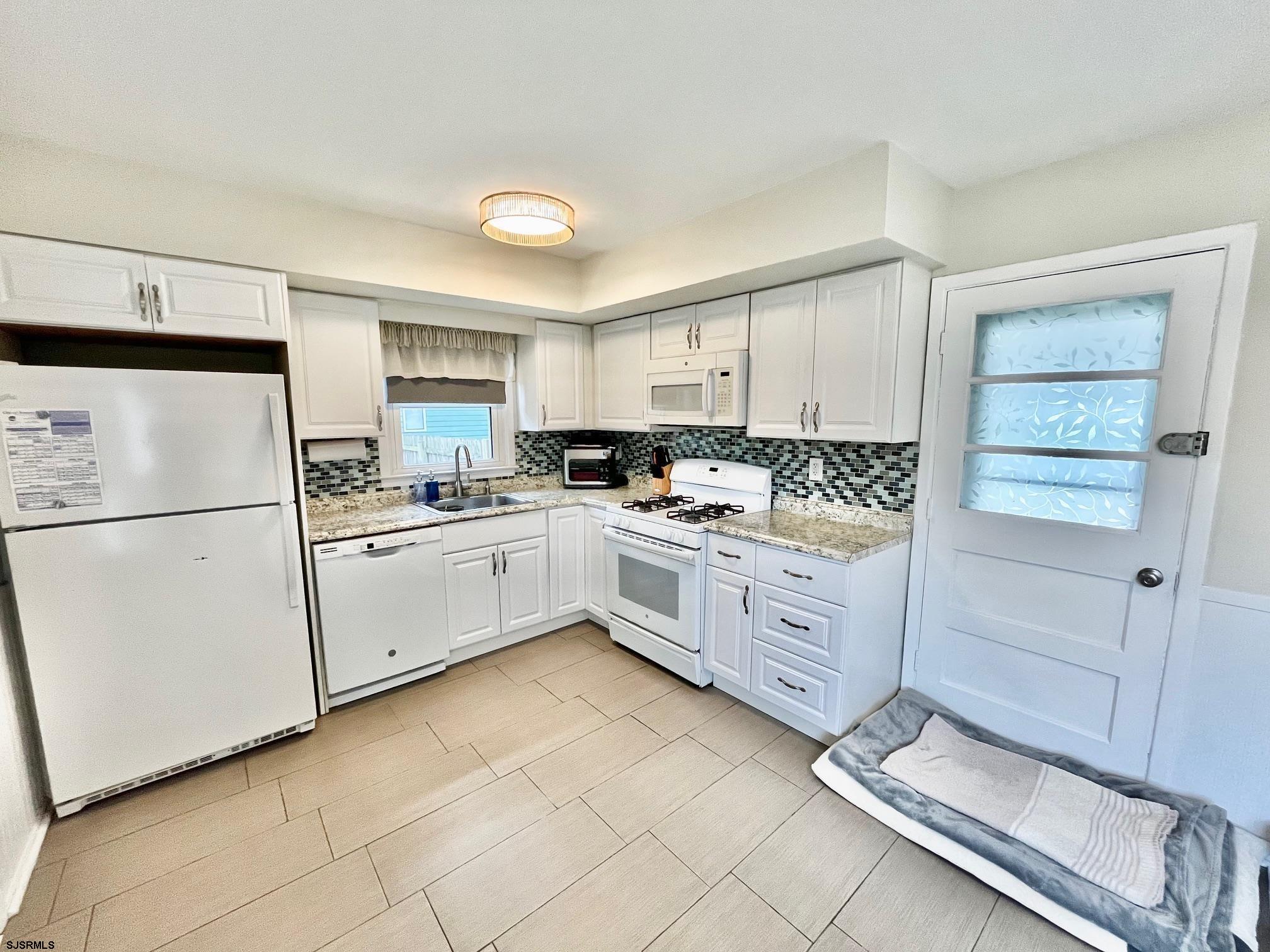 415 Rhode Island Avenue Somers Point, NJ 08244 - Photo 11 of 30 a kitchen with white cabinets and white appliances
