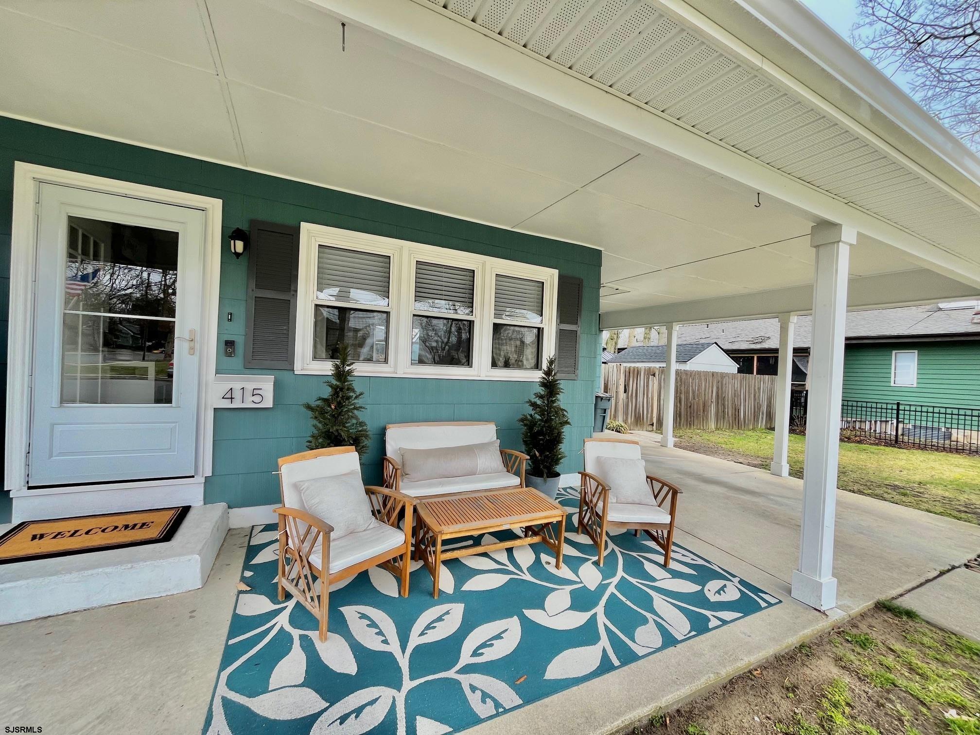 415 Rhode Island Avenue Somers Point, NJ 08244 - Photo 2 of 30 a view of a patio with table and chairs with wooden floor and fence