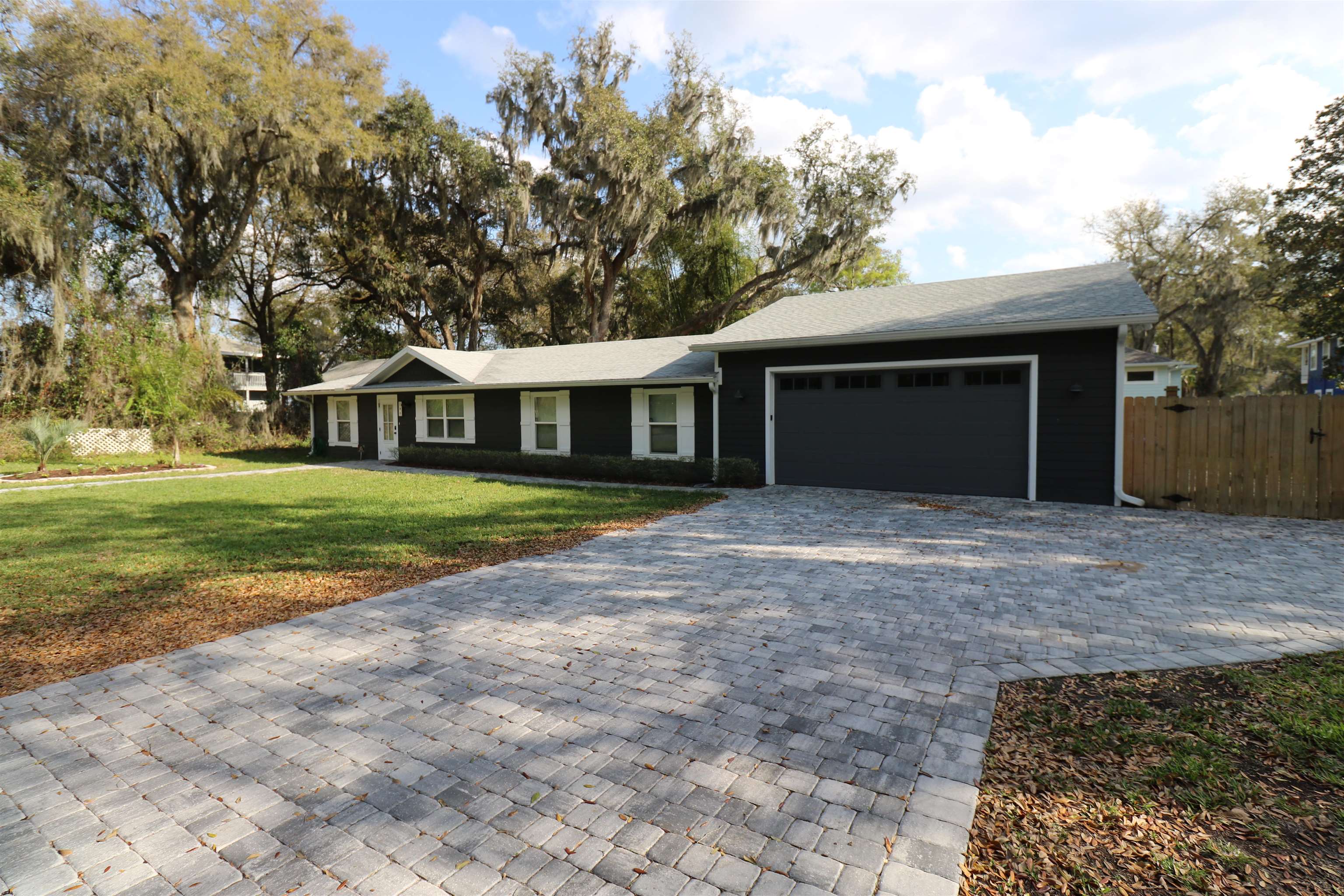 a view of a house with a yard and large tree