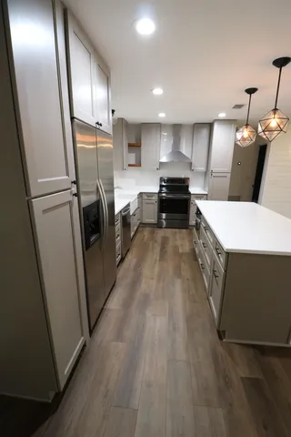 a large kitchen with a refrigerator a sink and dishwasher