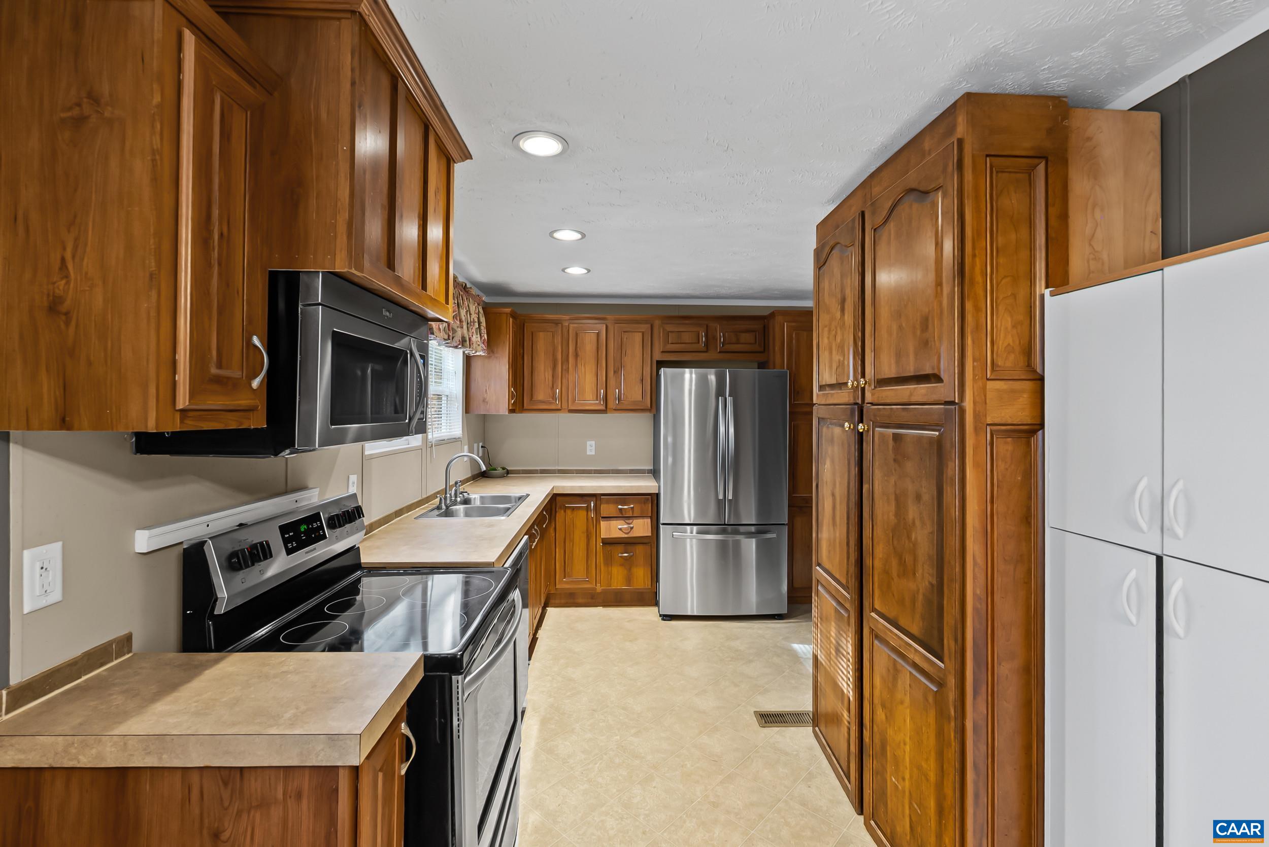 1690 Poorhouse Creek Road Appomattox, VA 24522 - Photo 10 of 44 a kitchen with stainless steel appliances granite countertop a refrigerator stove microwave and sink