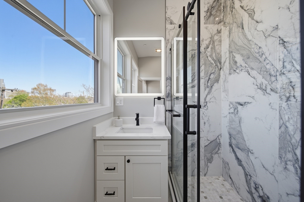 174 Walnut Street, Unit 3 Somerville, MA 02145 - Photo 13 of 38 a bathroom with a sink a vanity and a mirror