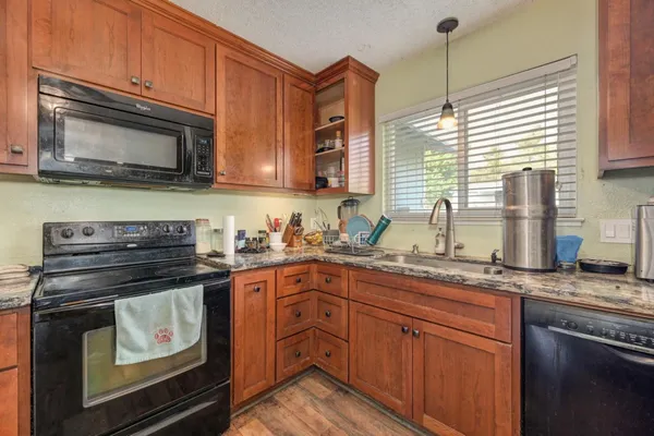 a kitchen with stainless steel appliances granite countertop a stove a sink and a microwave