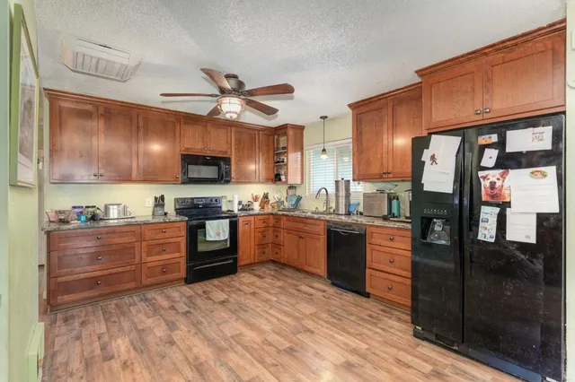 a kitchen with stainless steel appliances granite countertop wooden cabinets a stove top oven a sink and dishwasher