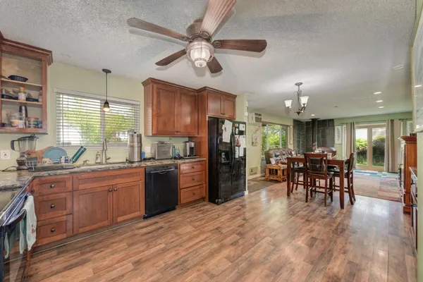 a kitchen with stainless steel appliances granite countertop dining table chairs refrigerator and cabinets