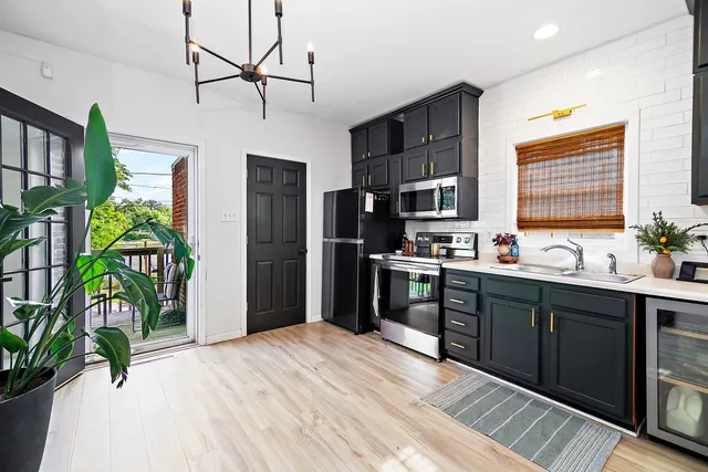 a kitchen with stainless steel appliances granite countertop a refrigerator a sink dishwasher a stove a refrigerator and a potted plant