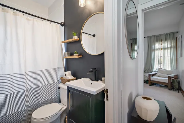 a bathroom with a sink a toilet and a mirror