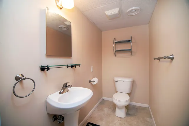 a bathroom with a toilet sink and mirror