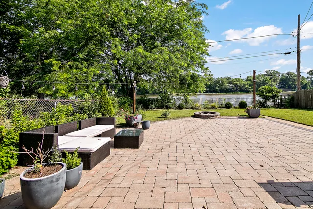 a view of a patio with couches and a table and chairs with wooden fence