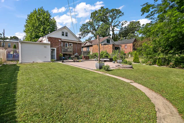 a front view of a house with a garden and trees