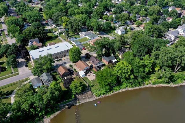an aerial view of residential house with outdoor space and trees all around