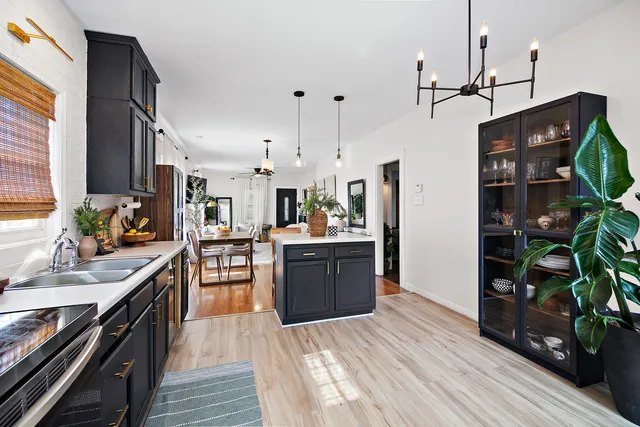 a kitchen with stainless steel appliances kitchen island granite countertop a sink stove and refrigerator