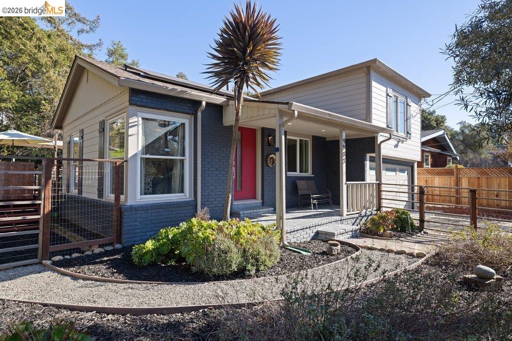 View of front of house featuring brick siding, covered porch, and an attached garage