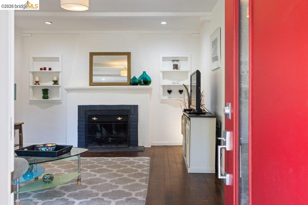 9600 Golf Links Road Oakland, CA 94605 - Photo 12 of 47 Living area with a brick fireplace, dark wood-style flooring, and built in shelves