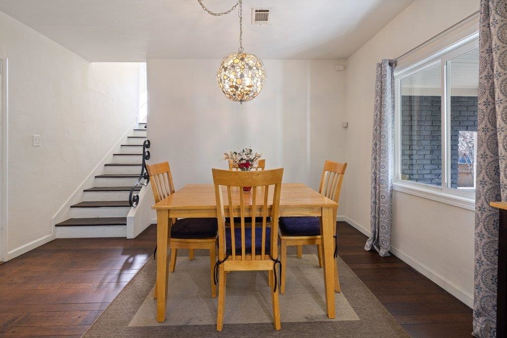 9600 Golf Links Road Oakland, CA 94605 - Photo 17 of 47 Dining space featuring dark wood finished floors, a chandelier, and stairs
