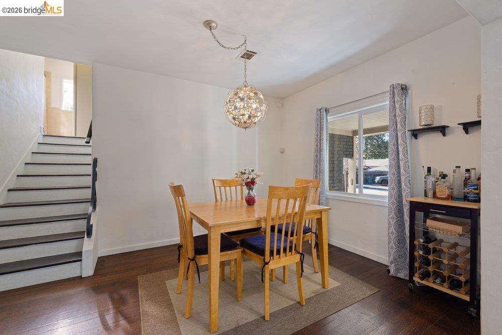 9600 Golf Links Road Oakland, CA 94605 - Photo 18 of 47 Dining area featuring dark wood-type flooring, stairway, and a chandelier