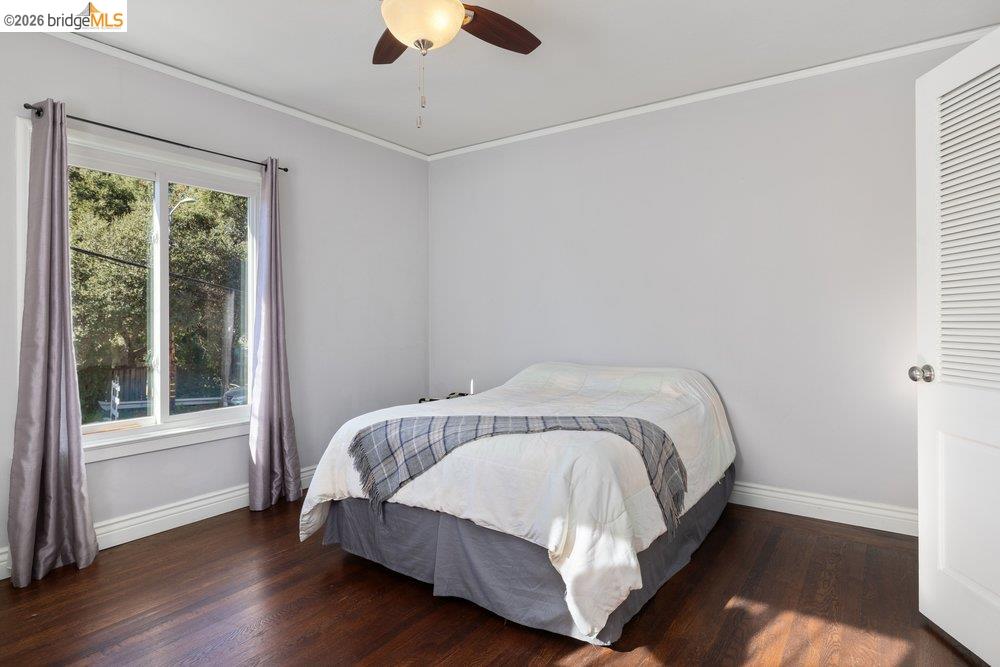 9600 Golf Links Road Oakland, CA 94605 - Photo 25 of 47 Bedroom featuring ornamental molding, dark wood-style floors, and a ceiling fan