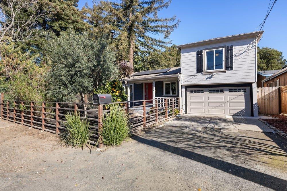 9600 Golf Links Road Oakland, CA 94605 - Photo 3 of 47 Tri-level home with roof mounted solar panels, driveway, an attached garage, and covered porch