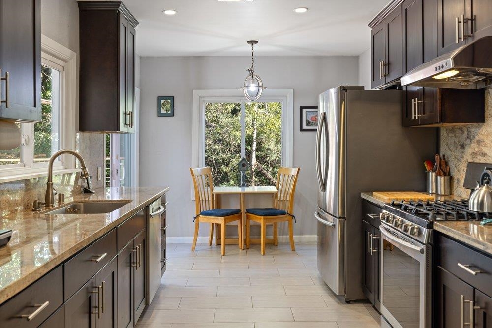 9600 Golf Links Road Oakland, CA 94605 - Photo 32 of 47 Kitchen with dark brown cabinets, stainless steel appliances, light stone counters, under cabinet range hood, and recessed lighting