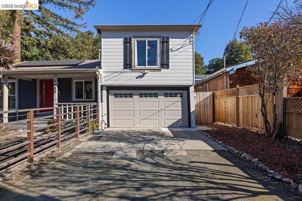 9600 Golf Links Road Oakland, CA 94605 - Photo 4 of 47 View of front of home with roof mounted solar panels, driveway, a garage, and covered porch