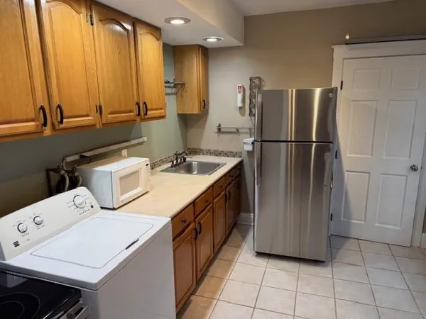 a kitchen that has a sink a stove and a refrigerator