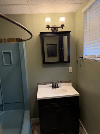 a bathroom with a sink vanity and mirror