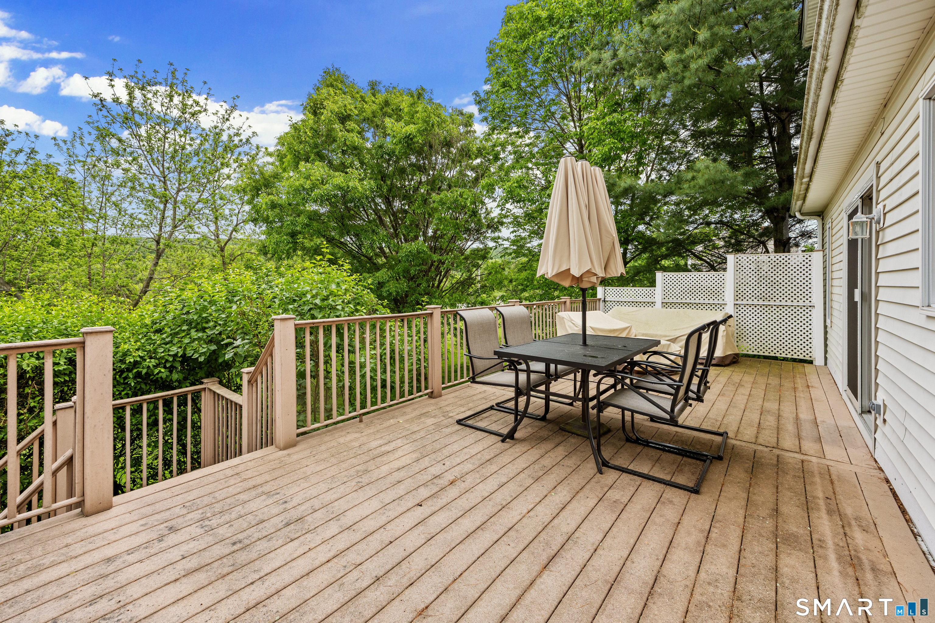 694 Millbrook Road Middletown, CT 06457 - Photo 29 of 34 a view of a roof deck with table and chairs with wooden floor and fence