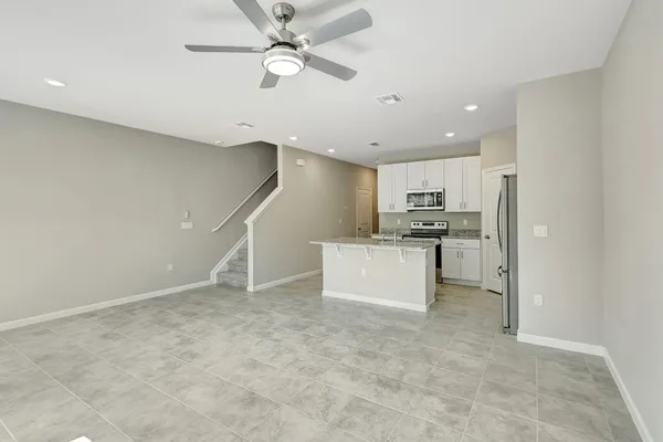a view of kitchen with stainless steel appliances refrigerator stove microwave and cabinets