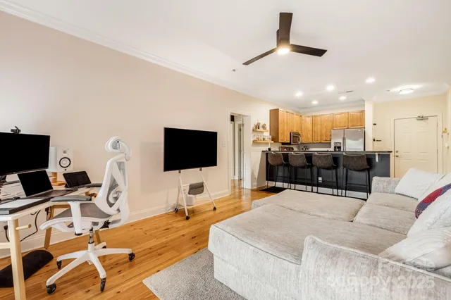 a living room with furniture kitchen view and a flat screen tv