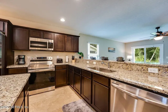 a kitchen with stainless steel appliances granite countertop a sink stove microwave and cabinets