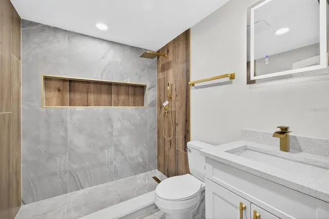 a bathroom with a sink a toilet and shower