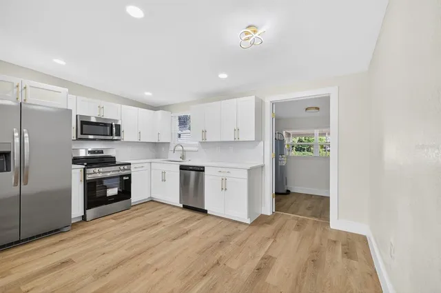 a kitchen with white cabinets and stainless steel appliances