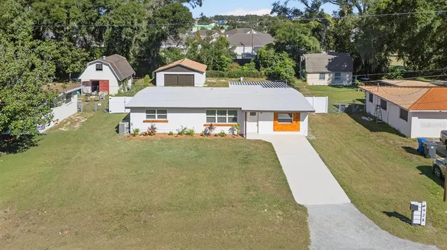 a front view of house with yard and trees in the background