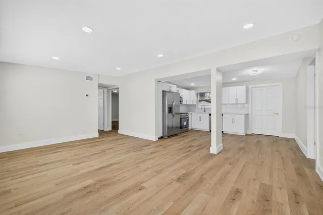 a view of an empty room with wooden floor