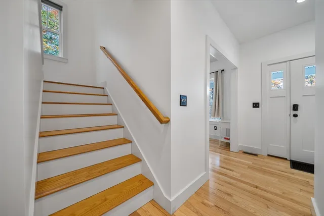 a view of a hallway with wooden floor and staircase