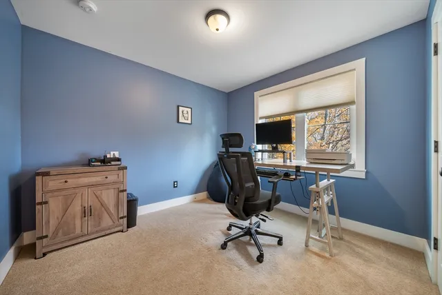 a view of a workspace with furniture and a window