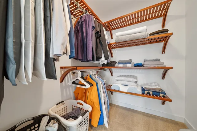 a view of walk in closet with clothes and shoes