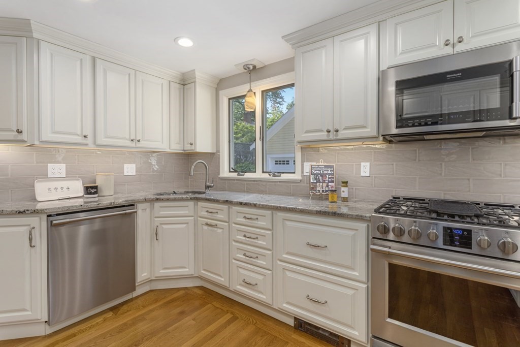 25 Oak Street Reading, MA 01867 - Photo 17 of 42 a kitchen with granite countertop white cabinets and appliances