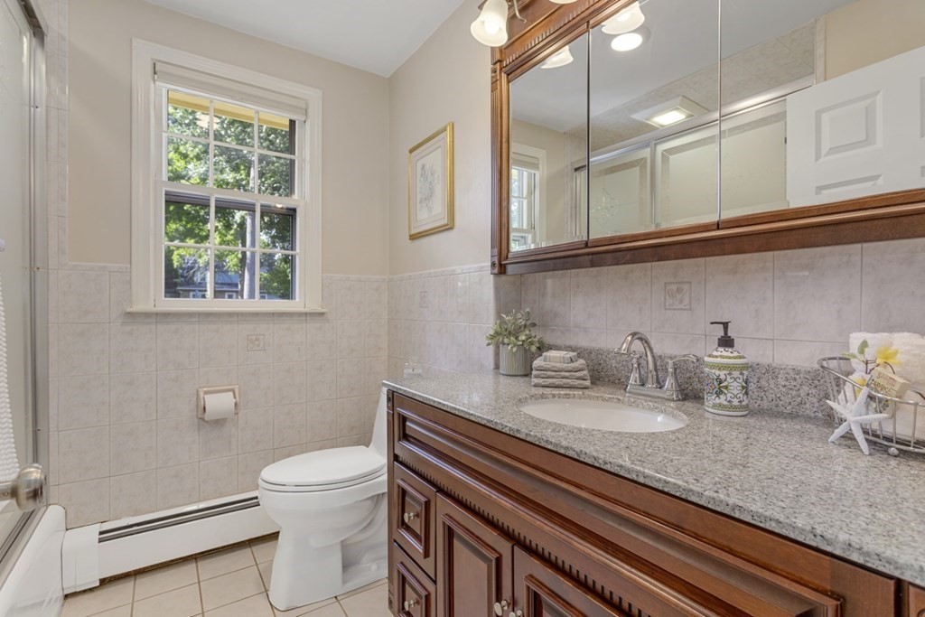 25 Oak Street Reading, MA 01867 - Photo 24 of 42 a bathroom with a granite countertop toilet sink and mirror