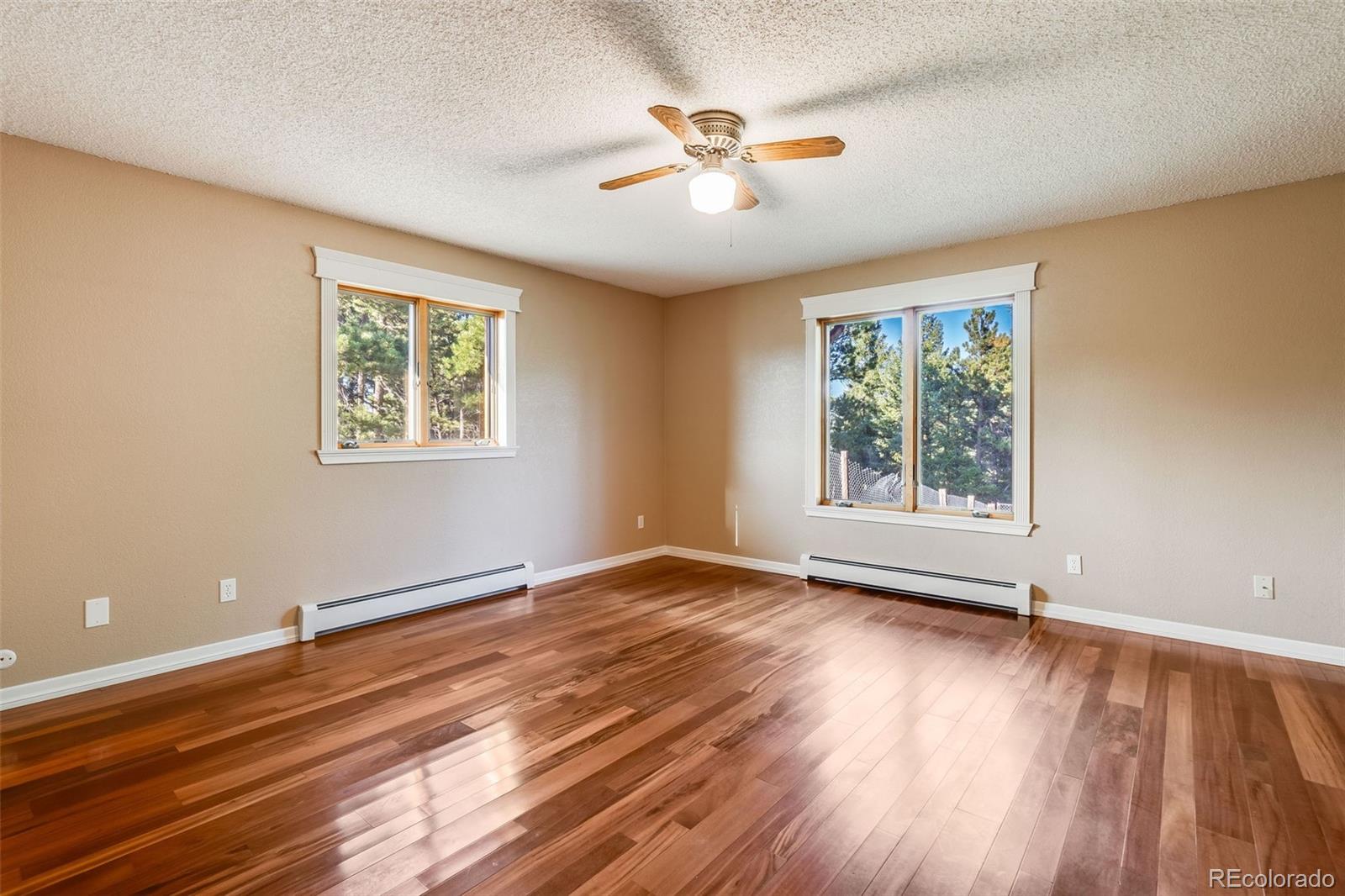 7572 Surrey Drive Morrison, CO 80465 - Photo 15 of 38 a view of an empty room with a window and wooden floor